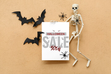 Composition with blank card, skeleton, bats and spiders on color background