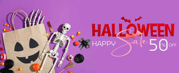 Composition with paper shopping bag, decorations and sweets for Halloween on purple background