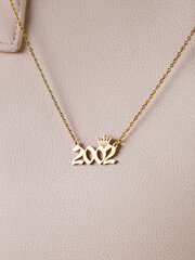 Close-up of a metallic gold pendant in the shape of 