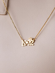 Close-up of a metallic gold pendant in the shape of 