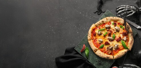 Tasty Halloween pizza and decorations on dark background with space for text