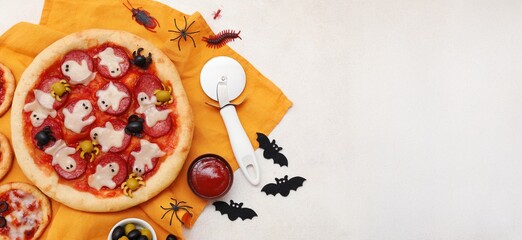 Tasty Halloween pizza and decorations on light background with space for text