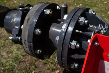 Fototapeta premium Industrial pipe fitting with metallic bolts and nuts, showcasing detailed craftsmanship and engineering in outdoor setting with natural lighting