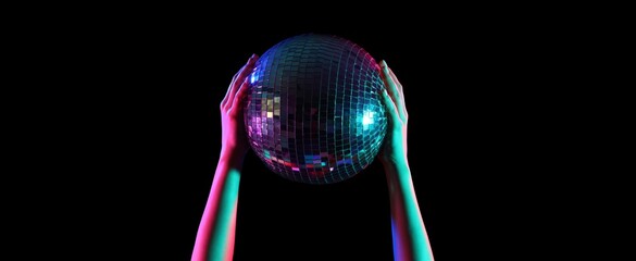 Toned female hands with disco ball on dark background