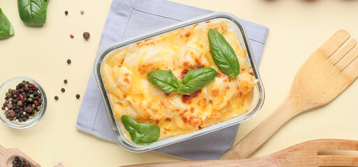 Baking dish of tasty pasta with cheese on beige background