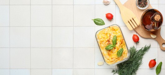 Baking dish of tasty pasta with cheese on light tile background with space for text