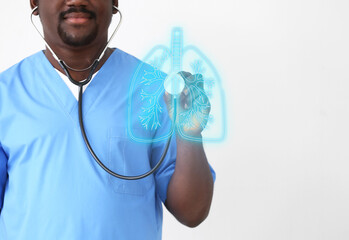 Male African-American nurse with stethoscope on light background