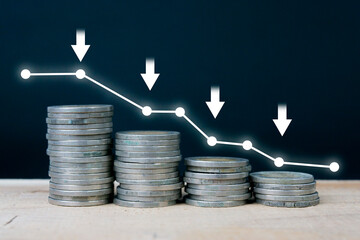 Stacks of coins and a downward trending chart. Economic recession crisis, inflation, stagflation,...