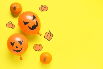 Funny Halloween orange balloons and paper pumpkins on yellow background