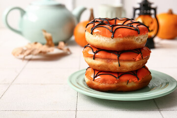 Plate of tasty donuts for Halloween on table
