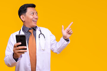 Cheerful Male Doctor Looking Away While Holding A Phone Against A Yellow Background