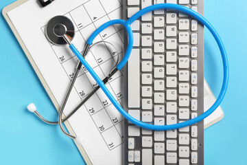 Modern computer keyboard, clipboard and stethoscope on blue background
