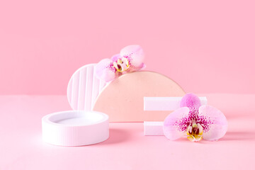 Decorative podiums with beautiful orchid flowers on pink background
