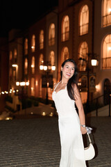 Young Asian woman tourist with long black hair in European style town at night