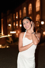 Young Asian woman tourist with long black hair in European style town at night