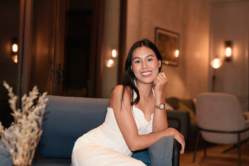 Young Asian woman tourist with long black hair in hotel sitting at night