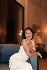Young Asian woman tourist with long black hair in hotel sitting at night