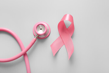 Stethoscope and pink ribbon on grey background. Breast cancer awareness concept