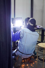 Welder performing Tungsten Inert Gas welding process (TIG) on stainless steel. TIG welding uses the heat generated by an electric arc struck between a non-consumable tungsten electrode and the work