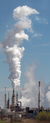 View of oil refinery flare and smoke stacks. Toxic refinery emissions.