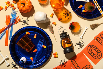 Composition with sweet treats, tableware and decorations for Halloween party on color background