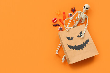 Composition with paper shopping bag, decor and sweets for Halloween on color background