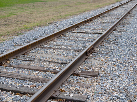 A photograph of railroad tracks diagonally stretching into the distance.