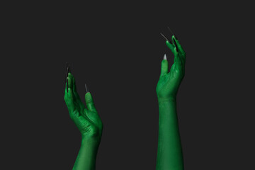 Green hands of witch on black background. Halloween celebration