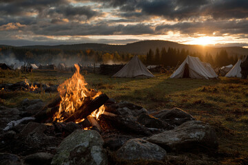 Campfire glows softly as twilight descends on the campsite