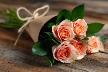 Bouquet of pastel roses arranged on a rustic wooden table