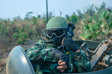 Soldier Using Communication Device, A soldier in full combat gear communicates via radio while riding inside an armored vehicle during a mission.