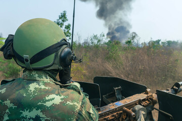 Soldier Using Communication Device, A soldier in full combat gear communicates via radio while...