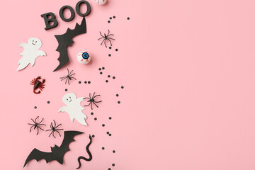 Composition with different decorations for Halloween on pink background