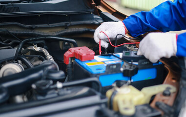 Auto mechanics check car engines with digital multimeters, test batteries and fuse boxes, and inspect electrical systems. Car service and maintenance.