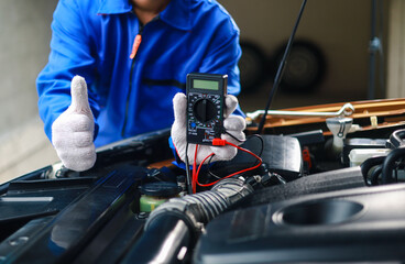 Auto mechanics check car engines with digital multimeters, test batteries and fuse boxes, and inspect electrical systems. Car service and maintenance.