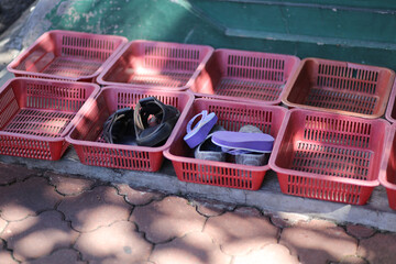 Sandals in Plastic Baskets at the Entrance of Indian Temple