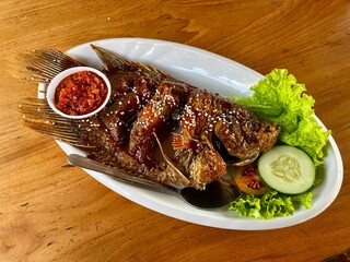 Grilled honey gourami menu served with lettuce, cucumber, tomato slices with special chili sauce