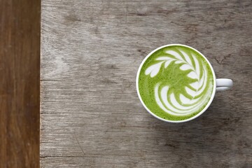 A cup of green tea matcha latte on wooden background                                                                                                                                                    