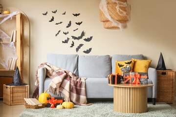Interior of festive living room with grey sofa, Halloween decorations and gift boxes