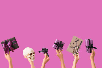 Female hands with Halloween gifts, skull, card and skeleton hand on purple background