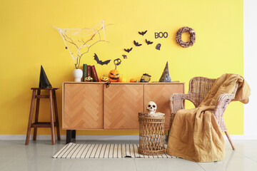 Living room with chest of drawers, coffee table and armchair decorated for Halloween celebration