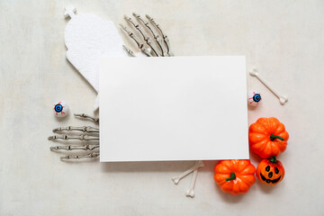 Composition with blank card and decorations for Halloween on light background