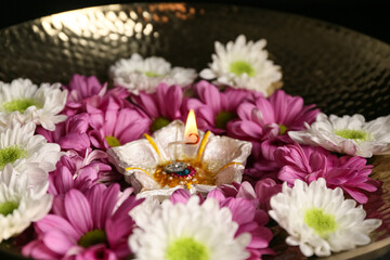 Plate with diya lamp and flowers, closeup. Divaly celebration