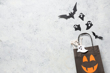 Shopping bag with Halloween paper decorations on grunge white background