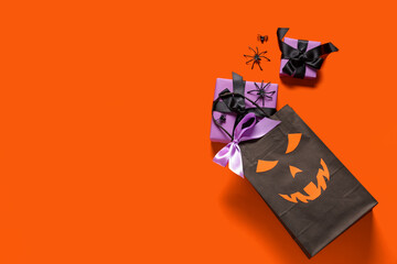 Shopping bag with Halloween gift box and spiders on orange background