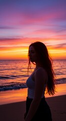 Fototapeta premium Sunset Silhouette at the Beach - A woman stands in silhouette on a beach, the vibrant sunset casting an orange and purple glow. The scene symbolizes peace, tranquility, solitude, hope, and beauty