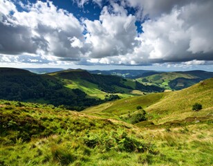 Obraz premium Green mountains stretch under a blue summer sky with puffy white clouds
