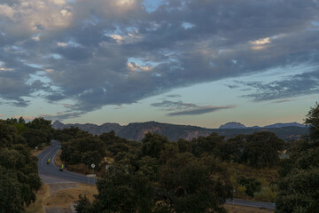 Bikers enjoying a scenic ride along a winding mountain road during a beautiful sunset