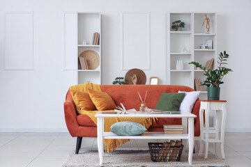 Coffee table with books, magazine and aroma sticks in stylish living room