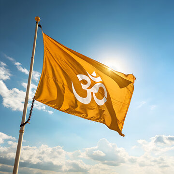 A yellow flag with the om symbol waves against a blue sky